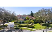 Stately two-story residence showcasing lush landscaping, a red tile roof, and a circular driveway at 9212 Island Lake Ct, Orlando, FL 32836