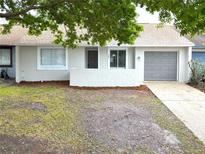 Charming single-story home with gray garage door, complemented by mature landscaping at 142 Long Leaf Pine Cir, Sanford, FL 32773