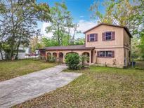 Inviting two-story home with a unique stucco facade, arched entry, and mature landscaping at 15523 Old Cheney Hwy, Orlando, FL 32828