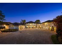 Magnificent two-story home with a vast driveway, garages, manicured landscaping, and elegant architecture at 3120 Downs Cove Rd, Windermere, FL 34786