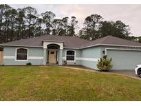 Charming single-story home with a well-manicured lawn, arched entryway and an attached two car garage at 3200 Utah Dr, Deltona, FL 32738