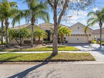 Stunning single Gathering home featuring well-manicured lawn, a paved driveway, and beautiful tropical landscaping at 4119 Navigator Way, Kissimmee, FL 34746