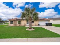 Charming single-story home with well-manicured lawn, palm tree, solar panels and attached garage at 4303 Tomlinson Cir, Orlando, FL 32829