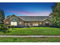 Charming single-story brick home with a well-manicured lawn and inviting curb appeal at 4537 Woodlands Village Dr, Orlando, FL 32835