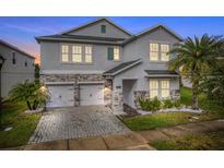 Charming two-story home showcasing a stone facade, a well-manicured lawn, and a two-car garage at 4622 Fairy Tale Cir, Kissimmee, FL 34746