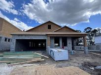 New construction home featuring a concrete block exterior and unfinished roof with a large garage at 5250 Prairie Preserve Run, St Cloud, FL 34772