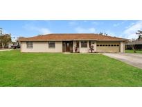 Charming single-story home featuring a manicured lawn and attached two-car garage at 7215 Scenic Pl, Lakeland, FL 33810