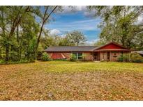 Charming brick home with unique nautical themed paint and lush greenery surrounding the front yard at 7252 June Bug Ln, Orlando, FL 32818