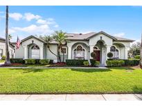 Inviting single-story home with manicured lawn, arched windows, and stately columns at 739 Spring Island Way, Orlando, FL 32828