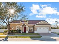 Charming single-Gathering home with a well-manicured lawn, brick driveway, arched entryway, and a two-car garage at 8712 Irmastone Way, Orlando, FL 32817