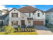 Beautiful two-story home featuring a stone facade, brown shutters, and a well-manicured front yard at 11464 Beau Repost Dr, Orlando, FL 32832
