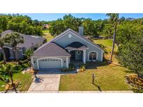 Charming single-Gathering home featuring a well-manicured lawn, lush landscaping, and an attached two-car garage at 1714 Golfview Dr, Kissimmee, FL 34746