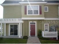 Charming two-story townhome with a red front door, covered entry, and lush green lawn at 4003 San Sebastian Dr # 108, Kissimmee, FL 34741