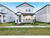 Charming two-story home with gray siding, landscaped yard and cozy front porch at 4673 Cross Prairie Pkwy, St Cloud, FL 34772