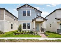 Charming two-story home with a light blue exterior and a well-manicured front yard at 5093 Railroad Vine Aly, Winter Garden, FL 34787