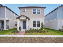 Charming two-story home with a blue front door and well-manicured lawn at 5099 Railroad Vine Aly, Winter Garden, FL 34787