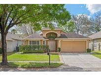 Charming single-story home with a manicured lawn and a two-car garage at 5580 Berwood Dr, Orlando, FL 32810