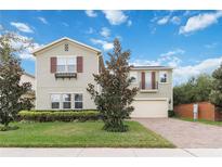 Charming two-story home with a brick driveway, manicured lawn, and beautiful curb appeal at 14504 Sunbridge Cir, Winter Garden, FL 34787