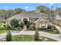 Stunning home with a well-manicured lawn, mature landscaping, and a welcoming entrance at 1554 Eagle Nest Cir, Winter Springs, FL 32708