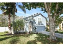 Charming two-story home featuring a manicured lawn, landscaping, and inviting curb appeal at 324 Lusitano Way, Sanford, FL 32773