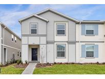 Charming two-story home with manicured lawn, paved walkway, and neutral-colored siding at 3974 Lana Ave, Davenport, FL 33897