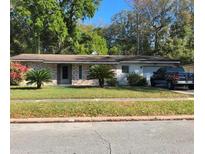 Charming single-story home featuring manicured front lawn, stone facade, and attached garage at 4313 Georgetown Dr, Orlando, FL 32808