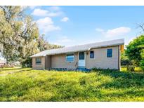 Ranch style home featuring neutral paint, and a welcoming front entry on a large grass lot with mature trees at 866 Gatlin Ave, Orlando, FL 32806