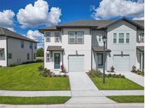 Charming two-story townhome with lush lawn, one-car garage, and inviting curb appeal at 929 Conch Rd, Davenport, FL 33896