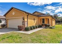 Charming home with a well-manicured lawn and stone accents on the garage and front columns at 9472 Sw 76Th St, Ocala, FL 34481