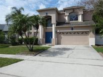 Charming two-story home features a well-maintained lawn, a two-car garage and a blue front door at 1230 Elegance Ct, Orlando, FL 32828