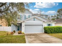 Charming two-story home featuring a gray exterior, two-car garage, and manicured lawn at 1317 Independence Ln, Mount Dora, FL 32757