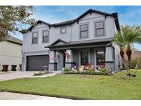 Charming two-story home featuring gray paint, well-manicured lawn, and an attached two-car garage at 2926 Boating Blvd, Kissimmee, FL 34746