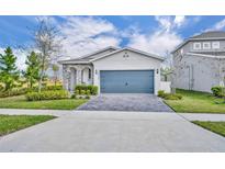 Charming single-Gathering home features a stone-accented facade, gray garage door and lush, green landscaping at 4426 Davos Dr, Clermont, FL 34711