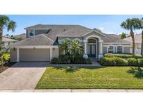 Charming two-story home featuring a well-manicured lawn, brick driveway, and mature landscaping at 713 Duff Dr, Winter Garden, FL 34787