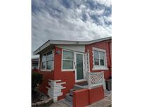 Red stucco house featuring a glass door and white trim detail with anchor accents at 833 E 24Th Ave # 106, New Smyrna Beach, FL 32169