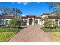 Charming one-story home showcasing a brick driveway and a well-manicured, beautifully landscaped front yard at 8718 Shimmering Pine Pl, Sanford, FL 32771