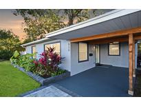 Charming home exterior with a covered porch, a well-manicured lawn, and colorful landscaping at 938 S Bumby Ave, Orlando, FL 32806