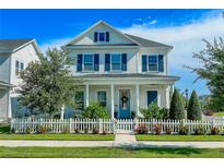 Charming two-story home featuring blue shutters and a well-manicured lawn with a white picket fence at 1024 Prosperity Dr, Winter Garden, FL 34787