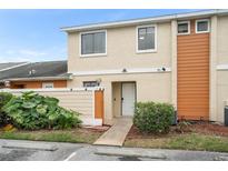 Inviting two-story townhome featuring a well-maintained front yard with mature landscaping at 15 Silver Park Cir, Kissimmee, FL 34743