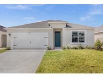 Charming single-story home featuring a neatly manicured lawn, attached two-car garage, and blue front door at 2921 Sunridge Loop, St Cloud, FL 34771