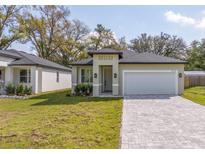 Charming one-story home featuring a two car garage, a well-maintained lawn, and a paved driveway at 313 Mandrake St, Orlando, FL 32811