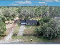 Charming single-story home featuring an attached garage and a spacious front yard with mature trees at 425 Old Chuluota Rd, Chuluota, FL 32766