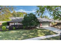 Charming single-story home featuring a stone facade, well-manicured lawn, and mature trees at 460 Forestwood Ln, Maitland, FL 32751