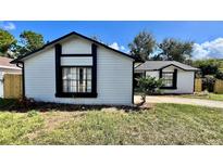 Charming single-story home featuring white siding and bold black trim around the windows at 5317 Hyde Park Ave, Orlando, FL 32808