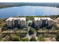 Scenic aerial view of lakeside condos, pool, and lush landscaping at 6336 Buford St # 706, Orlando, FL 32835