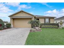 Charming single-story home with a well-manicured lawn, beautiful landscaping, and a two-car garage at 10139 Grande Loop, Clermont, FL 34711