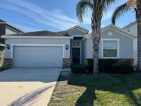 Charming one-story home with a two-car garage and a well-maintained lawn at 1574 Thetford Cir, Orlando, FL 32824