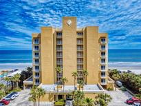 Stunning exterior view of a beachfront condo building featuring a large seashell emblem and multiple balconies at 1705 S Atlantic Ave # 402, New Smyrna Beach, FL 32169