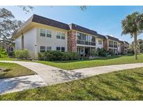 A welcoming condo complex with lush landscaping and well-maintained sidewalks on a bright, sunny day at 3800 Saxon Dr # 19B, New Smyrna Beach, FL 32169