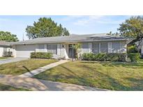 Well-maintained single-story home with stone accents, shutters, and a green lawn at 4913 E Wind St, Orlando, FL 32812